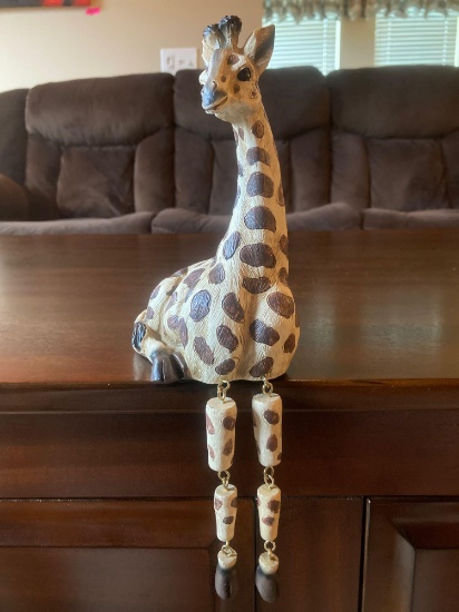 Giraffe statue with hanging legs