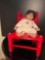 Red Painted Antique Child's Chair and Black Haired Baby Doll