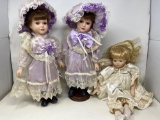 3 Porcelain Dolls- 2 in Purple Outfits and One in Cream Outfit