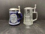 2 Steins with Pewter Lids- One Ceramic with Relief Design and One Etched Clear Glass