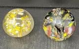 2 Glass Paperweights- Yellow/White and Black/Multicolor Floral
