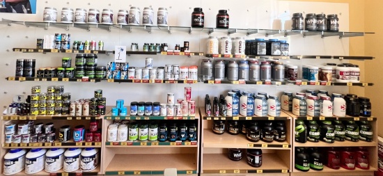 LARGE LOT OF NEW PROTEIN POWDER AND RETAIL CABINETS