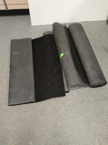 Several rolls of long rugs