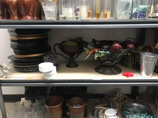 Shelf of decorate decorative platters buckets and fake fruit