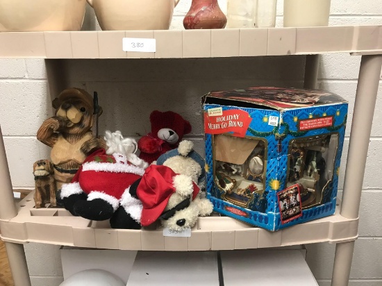 Shelf contents includes Mr. Christmas holiday merry go round wooden bear hunter Santa Claus and two