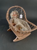 Wicker cradle with bisque doll, compo body