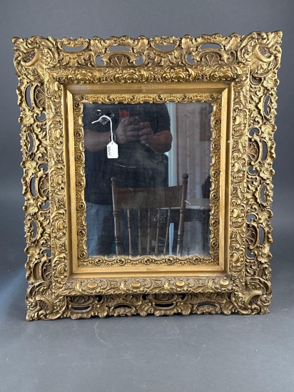 Heavily carved gold frame with mirror
