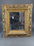 Heavily carved gold frame with mirror