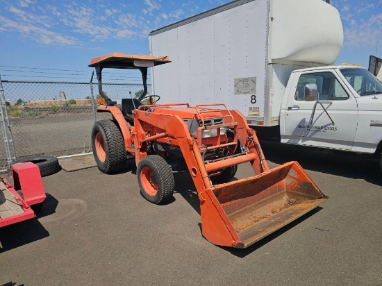 Kubota L-Series compact 4x4 utility tractor equipped with a front-end loader attachment