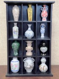 Shadow box with 12 miniature jugs