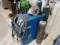 MILLER MILLERMATIC 350 WIRE WELDER W/ WELDING HELMENT, STRIKERS,  3-COMPRESSED GAS BOTTLES, & ROLLIN
