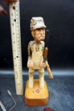 Wooden carved hunter with shotgun, incense burner, replica artifact.