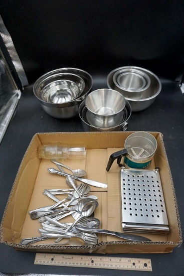 Stainless steel bowls, cutlery, kitchen supplies.