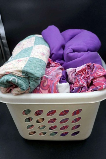 Basket with quilts and linens.