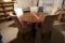 Large modern dining table with five chairs, each of the five chairs is a slightly different color. O