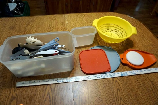 Assorted tupperwares, lids, strainer, kitchen utensils.