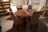 Large modern dining table with five chairs, each of the five chairs is a slightly different color. O
