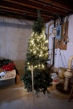 Tall faux Christmas tree, pre lit, some lights working.