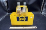 Plastic Pepsi crate with vintage glass bottles.