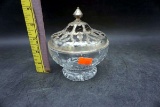 Glass bowl with metal lid.