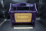 Purple magazine rack with cane.