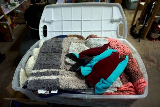 Tote full of rugs, linens, blankets. Handmade blankets.