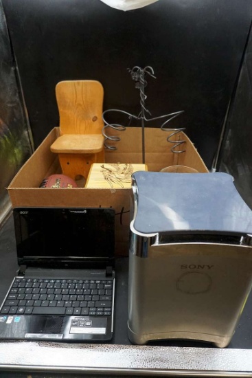 Sony subwoofer, Acer. Computer, wine bottle holder, wooden chair, football, dragonbox, glassware.