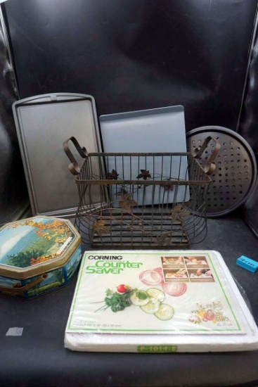 Metal basket, cutting board, pans, tin canister.