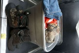 Tote full of clothing, work boots, Huskers gear, camouflage, and more.
