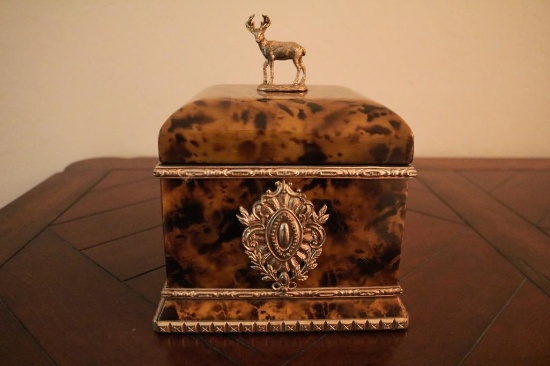 Brown square box with bronze buck on top
