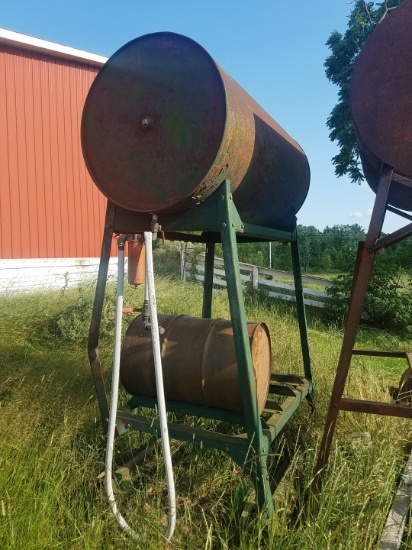 Fuel barrel on stand. Painted Green. 300 gallon. One stand leg has a bend.