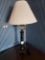 Table lamp, black column, with glass hurricane globe beneath shade