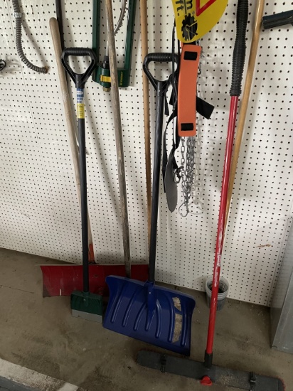 Large group of shovels, brooms, and other yard tools