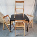 Textured Black Folding Table And 4 Blonde Folding Slat Seat Chairs