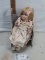 porcelain doll in music box chair