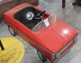 Red plastic pedal car, one tire is off