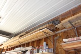 Lumber, soffit, on shelves on north wall, west side