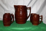 RED WING LARGE BARREL PITCHER AND (4) LARGE BARREL MUGS, SMALL CRACK ON SPOUT