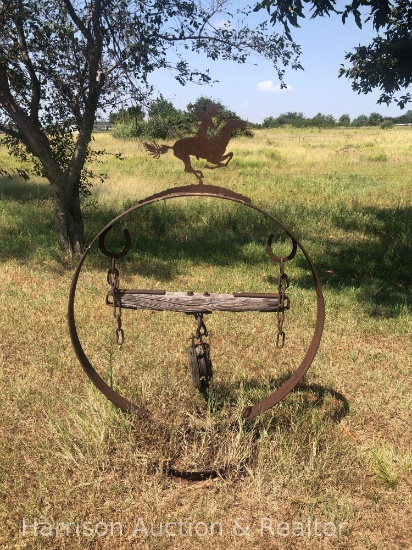 Metal yard art with Native American on top of the metal ring.