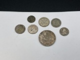 SEVEN ASSORTED SILVER COINS FROM VARIOUS PARTS OF THE WORLD