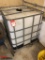 250-GALLON PLASTIC TOTE WITH FORKABLE METAL CAGE AROUND THE TANK