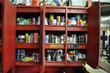 Contents of red cabinet including spray guns, spray paint, fluids & welding rod