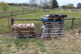 Pile of firewood and pallets next to machine shed