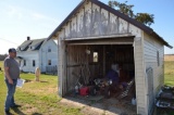 Contents of shed by road including tire rack by road also includes some scrap iron