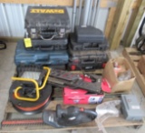 Contents of pallet including work light, extension cord, empty tool cases,