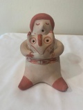 Red on cream seated figure holding an Owl