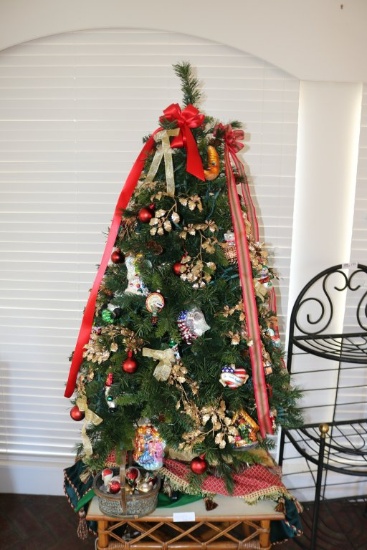 Decorated Christmas Tree, a Basket of Ornaments and Christmas Linens