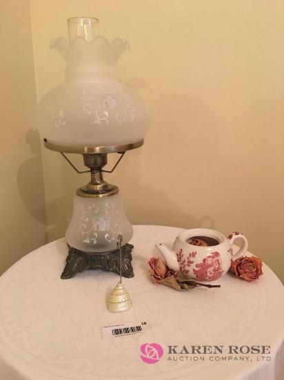 Round dressed end table with Antique knickknacks, antique glass lamp