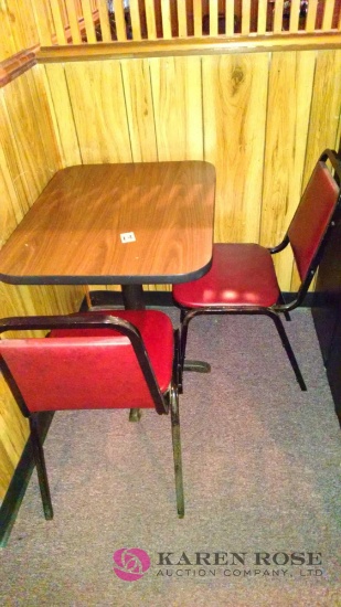 3o x 24 table with two red cushioned chairs