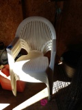 Four stackable white plastic chairs